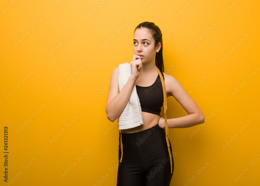 Young fitness girl doubting and confused