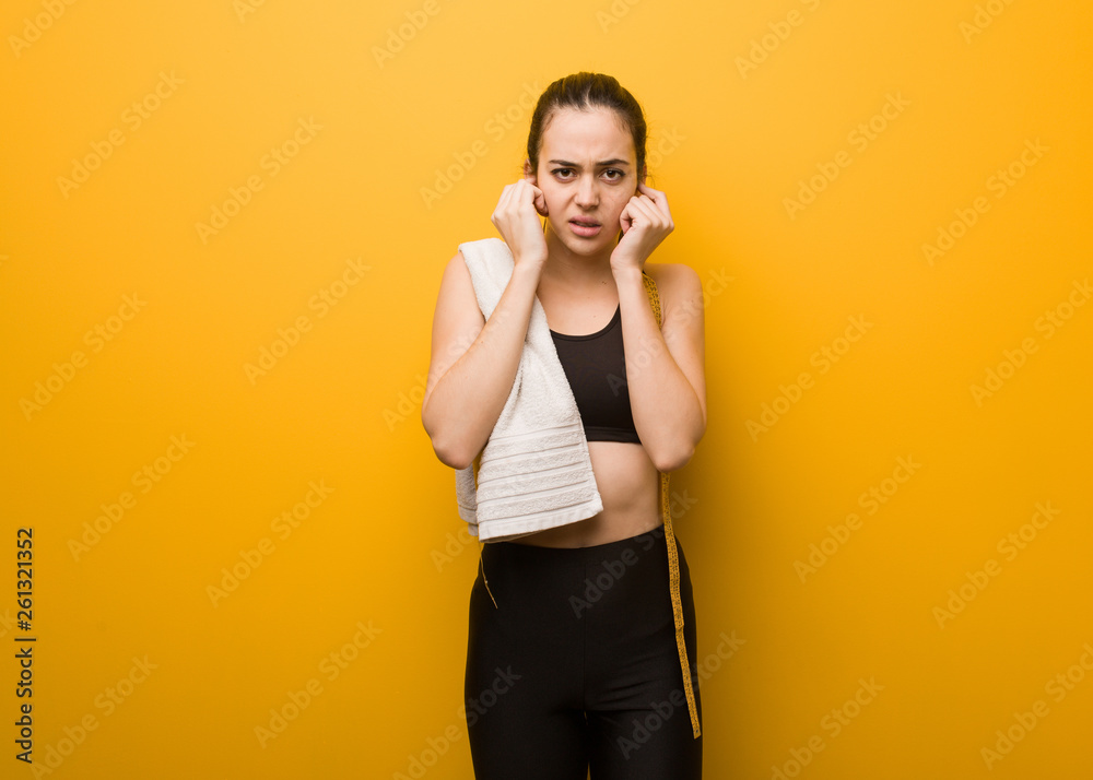 Young fitness girl covering ears with hands Young fitness girl covering ears with hands