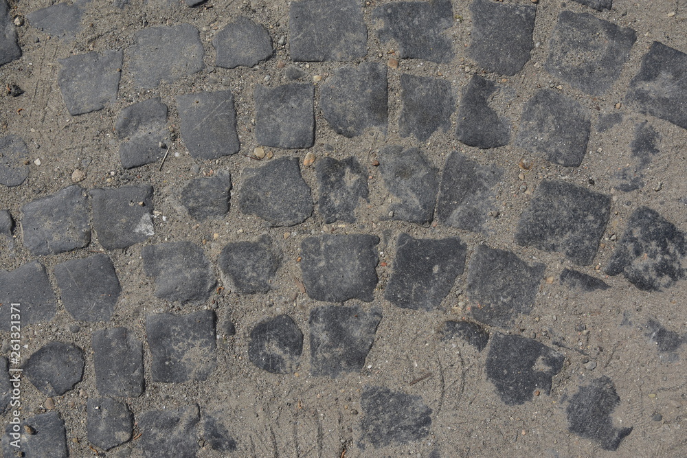 An old street with a cobblestone covered with sand An old street with a cobblestone covered with sand