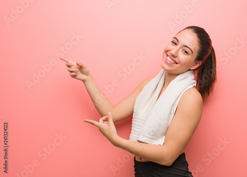 Young fitness woman pointing to the side with finger