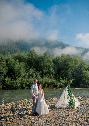 Newly married wedding couple hugging on nature