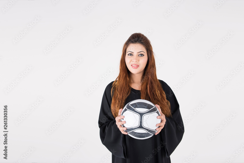 Beautiful Arab woman in traditional dress carrying soccer ball