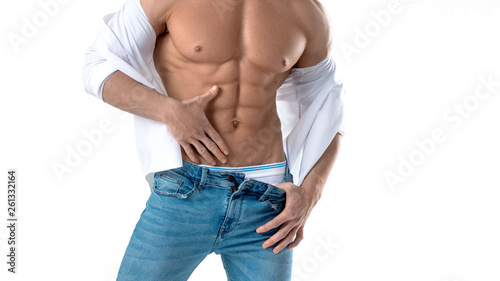 Muscular male torso in white shirt and blue jeans isolated on white