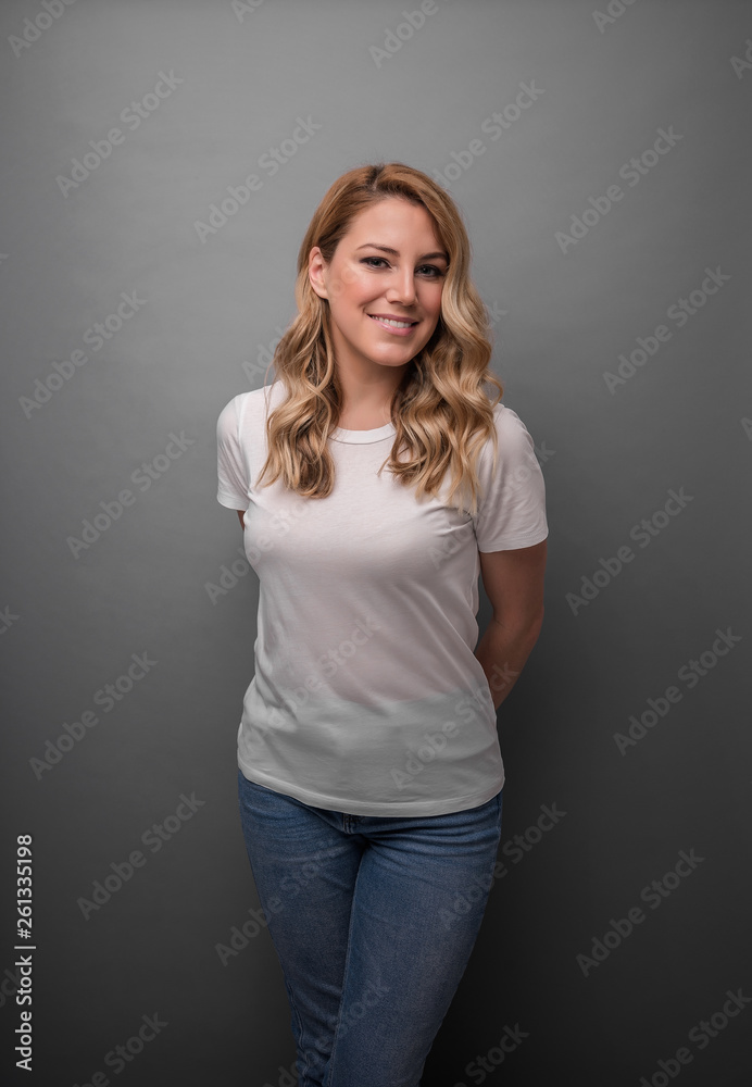 Beautiful blonde is smiling. Studio photo of a young attractive woman on a gray background. Beautiful blonde is smiling. Studio photo of a young attractive woman on a gray background.