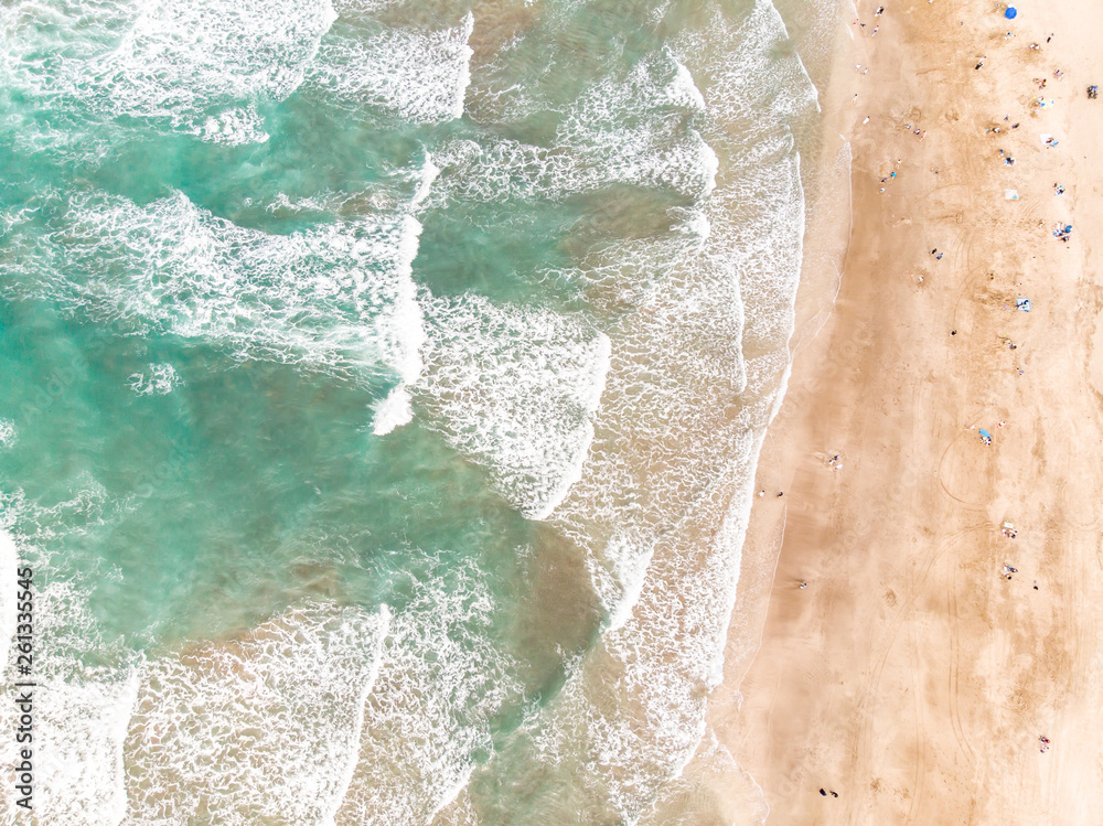 Aerial view of sandy beach with tourists swimming in beautiful clear sea water Aerial view of sandy beach with tourists swimming in beautiful clear sea water