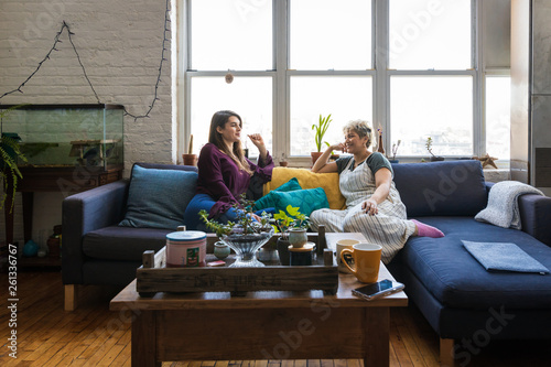 Friends talking together on a couch at home