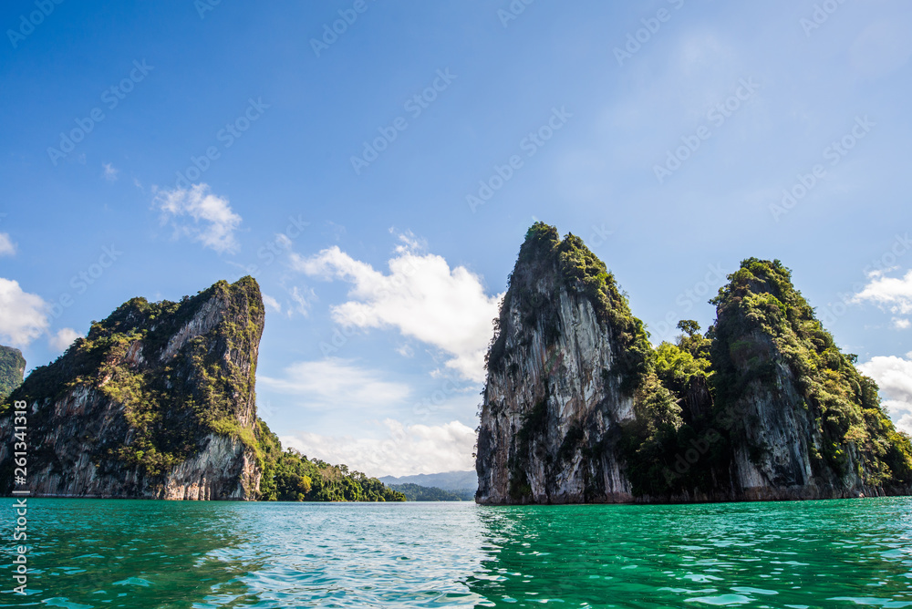 Beautiful nature rock mountains cliff and blue emerald water color lake river with blue clear sky in Ratchaprapa Dam at Khao Sok National Park, Surat Thani Province, Thailand. Asia tourism location.