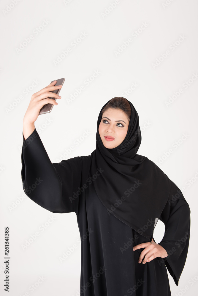 beautiful arab girl taking selfie with her smart phone beautiful arab girl taking selfie with her smart phone