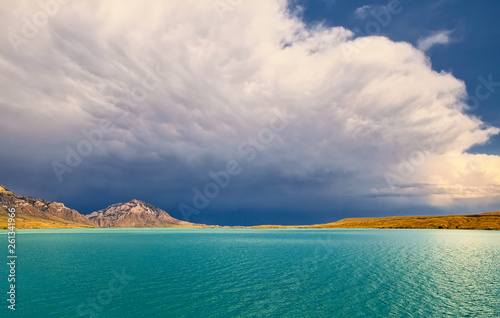 фотографія Beautiful aqua water with mountains and a valley in the distance under a cloudy