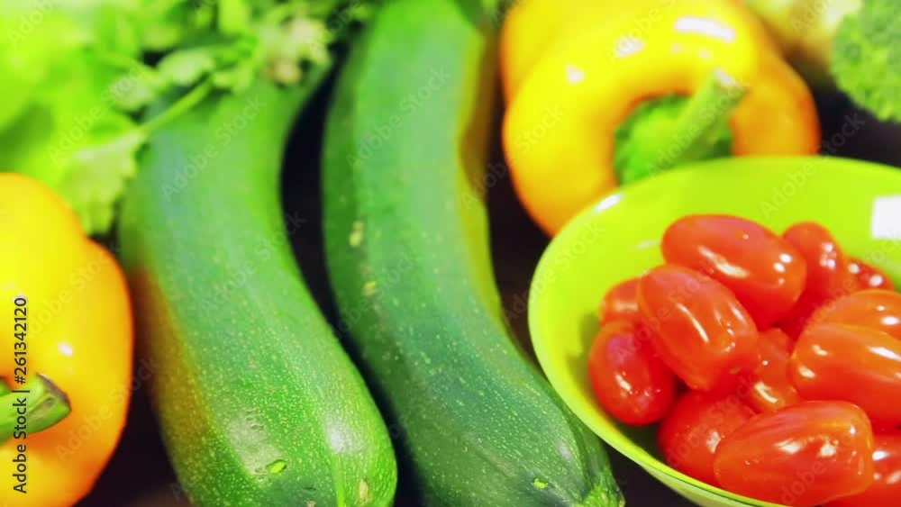 On the wooden table are fresh vegetables zucchini, broccoli, lettuce, avocado, cucumbers, pepper and chili pepper, cherry tomatoes. Close-up On the wooden table are fresh vegetables zucchini, broccoli, lettuce, avocado, cucumbers, pepper and chili pepper, cherry tomatoes. Close-up