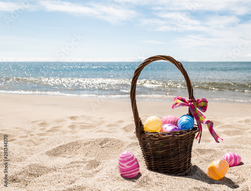 Fototapeta Naklejka Na Ścianę i Meble -  Easter bunny with color eggs on the ocean beach