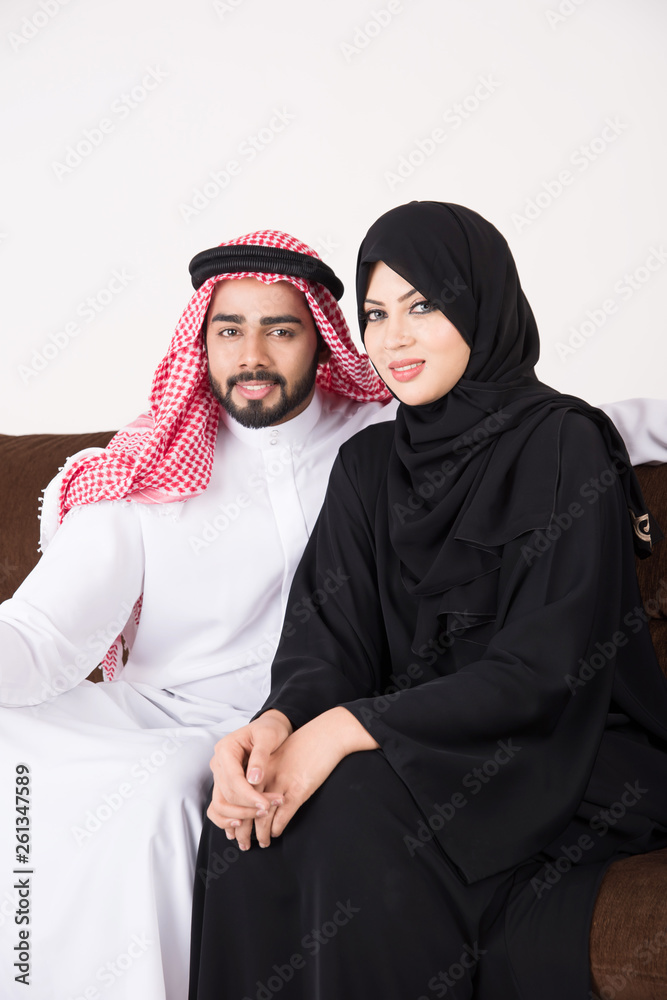 Arab couple sitting on sofa chair at home