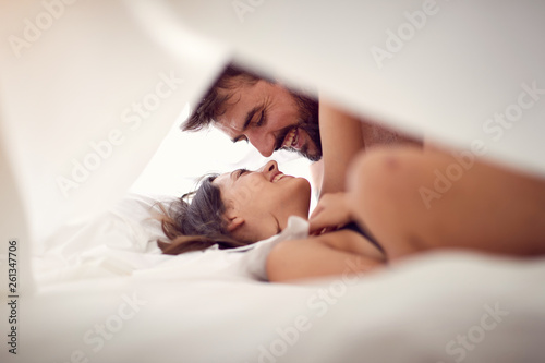 beautiful young couple lying and hugging in bed. photo