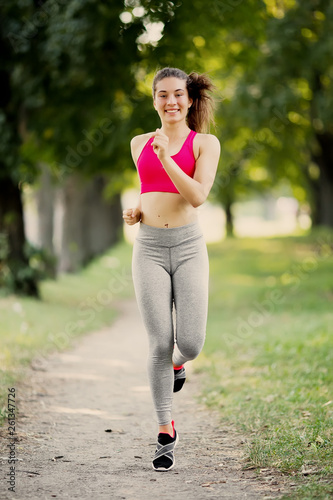 Young fitness woman running around in the park.