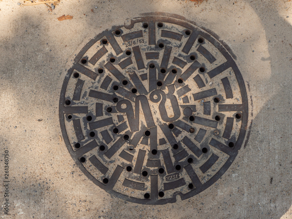 Manhole cover on pavement with patterns. Thailand. Manhole cover on pavement with patterns. Thailand.