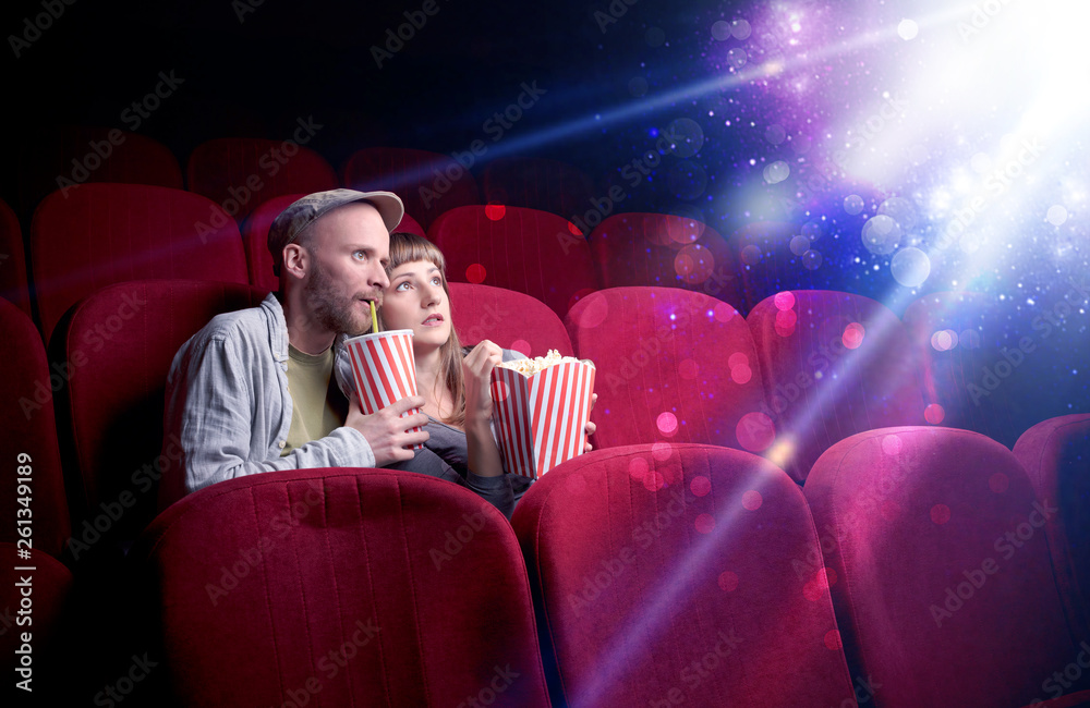 Obraz premium Romantic couple cuddling and watching the miraculous part of the film