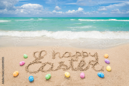 Happy easter lettering background with eggs on the sandy beach