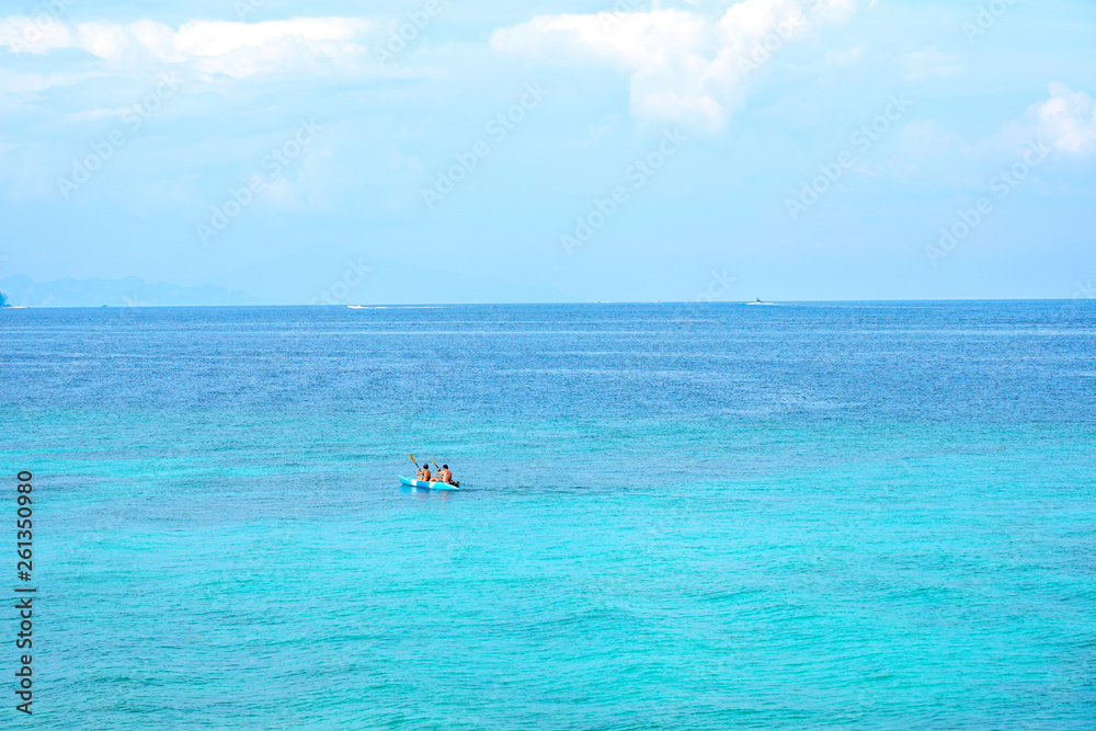 Traveller couple kayaking boat on summer tropical beach with blue sky background.Day off to ocean paradise.Happy Vacation holiday in beautiful outdoor scene landscape. Travel Journey Freedom concept. 