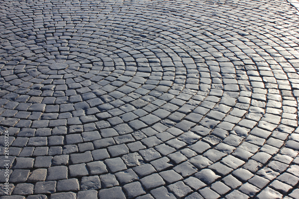 Cobblestone pavement texture and stone pattern of street with sun reflection