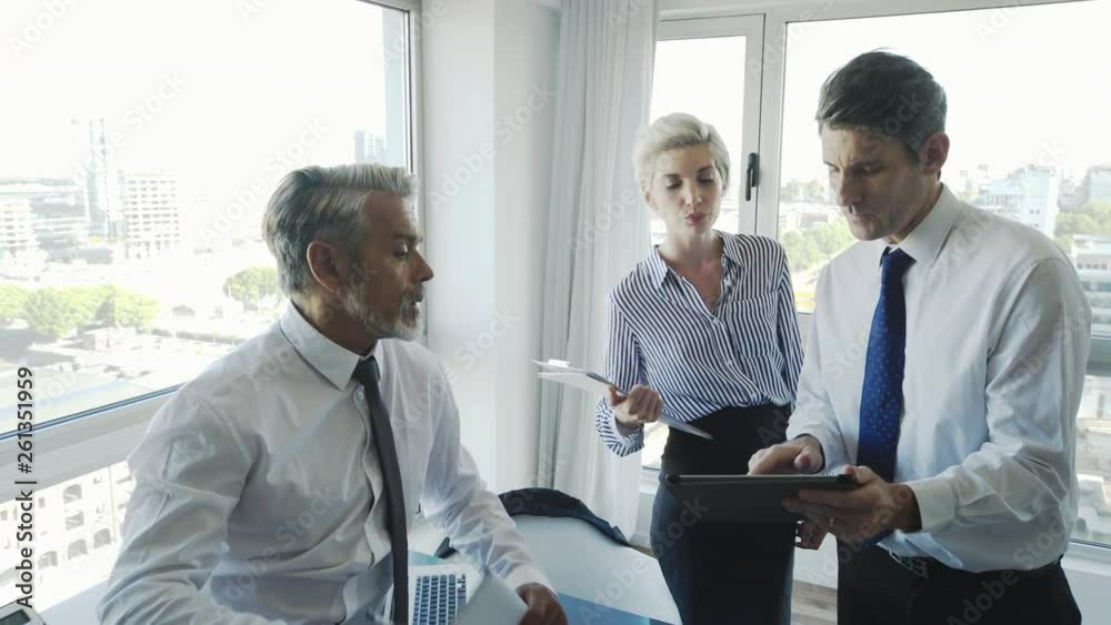 Medium shot of business people using digital tablet in office Medium shot of business people using digital tablet in office