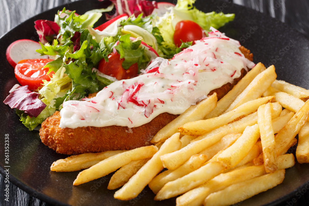 fish in breading with a side dish of french fries and fresh salad close-up. horizontal fish in breading with a side dish of french fries and fresh salad close-up. horizontal
