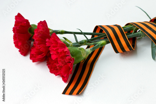 Arrangement of a bouquet of carnations and St.George ribbon in honor of the Victory Day holiday on may 9 photo