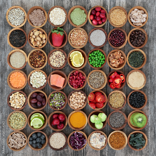 Large healthy super food collection in wooden bowls on rustic wood. High in antioxidants, anthocyanins, protein, smart carbs, vitamins and dietary fibre. Flat lay.