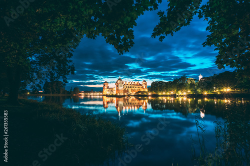 Mir, Belarus. Night Scenic View Of Mir Castle In Evening Illumination With Glow Reflections On Lake Water. UNESCO World Heritage Site. Famous Landmark, Ancient Gothic Monument. Popular Destination © Grigory Bruev