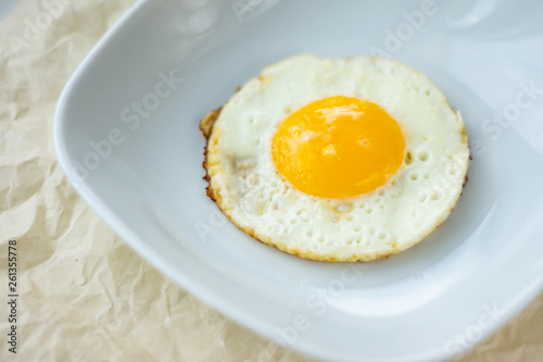 Round fried egg in the plate.