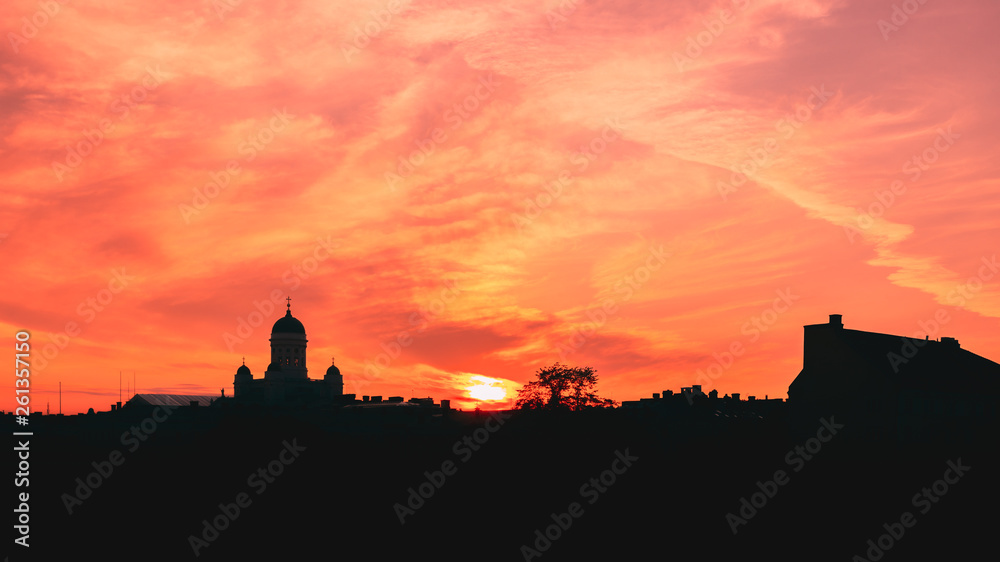 Helsinki, Finland. Famous Landmark Is Lutheran Cathedral In Evening Lighting. Dark Silhouette Of Cityscape Skyline In Backlit At Sunset On Colourful Orange And Yellow Colours Dramatic Sky