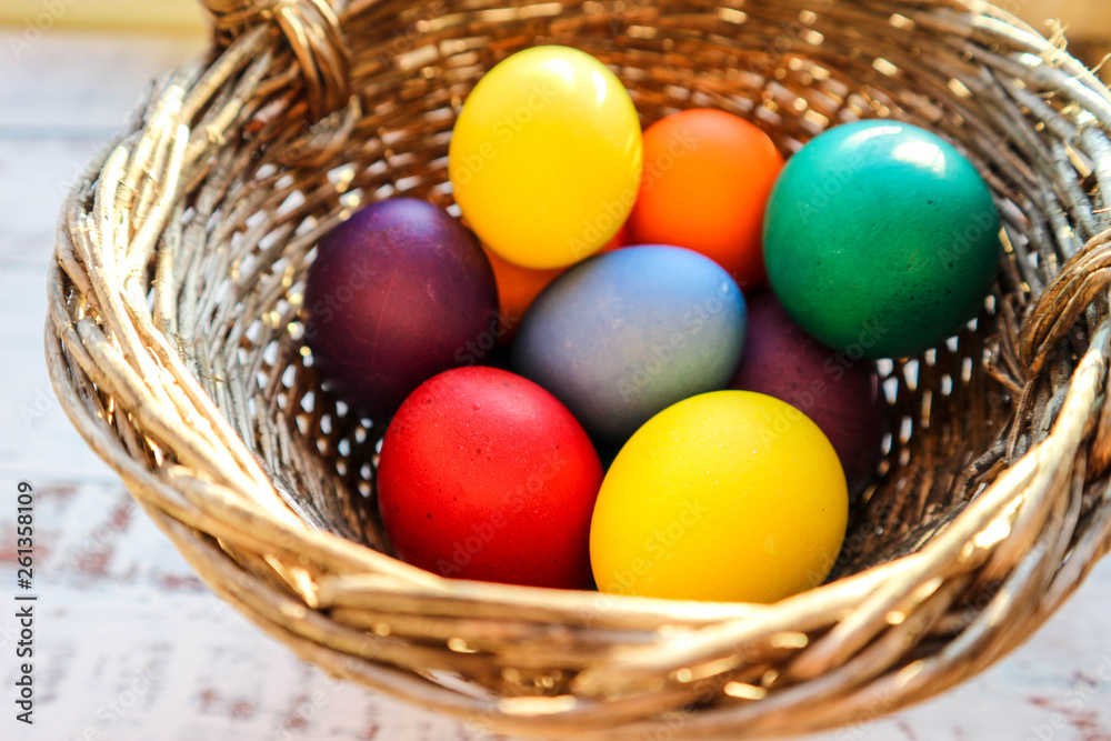 pack of colorful easter eggs in vintage basket closeup