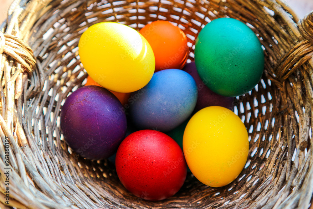Bright colorful easter eggs in a basket closeup