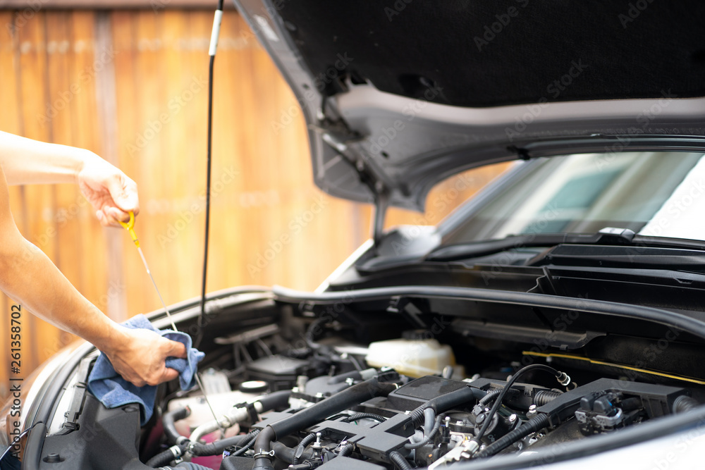 Fototapeta premium Mechanic man working and repair or checking car oil engine in car service center.Automobile metal car engine part details.Concept of modern vehicle motor,Industry,Mechanic and Business.