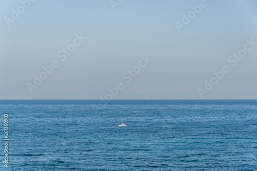 Tiny Fishing Boat on the Blue Italian Mediterranean Sea on a Clear Sunny Day © JonShore