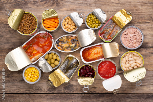 Canned food on wooden background, top view  photo
