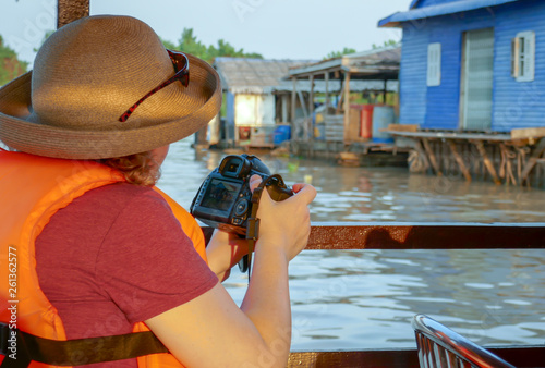 Photographer shooting floating fishing village of Tonle Sap River in Cambodia photo