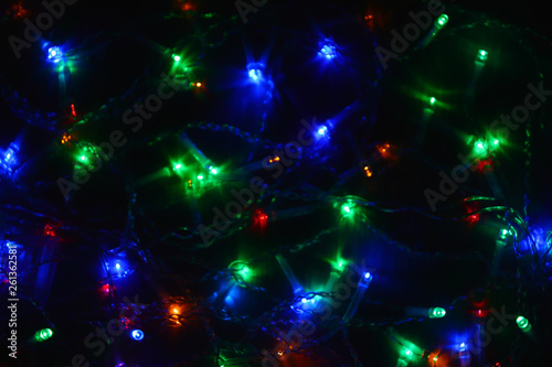 Colored lights (garland) in the dark. Bokeh effect Festive illumination.