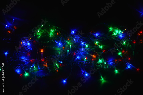 Colored lights (garland) in the dark. Bokeh effect Festive illumination.