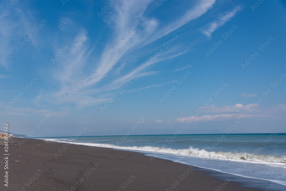 Cloudscape and Volcanic Black Sand Beach and Blue Ionian Sea in Sicily
