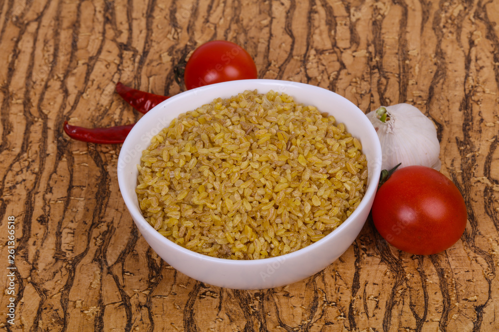 Raw bulgur in the bowl with tomatoes and garlic Raw bulgur in the bowl with tomatoes and garlic