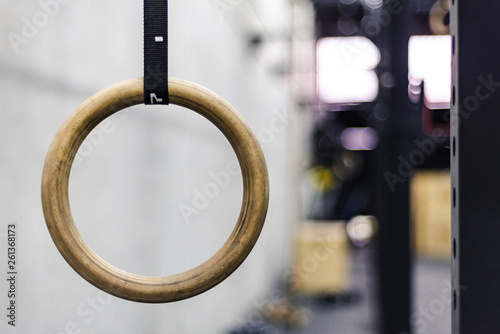 Gymnastic ring hanging in gym on blurred background photo