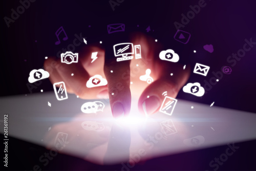 Finger touching tablet with white drawn application icons and dark background

