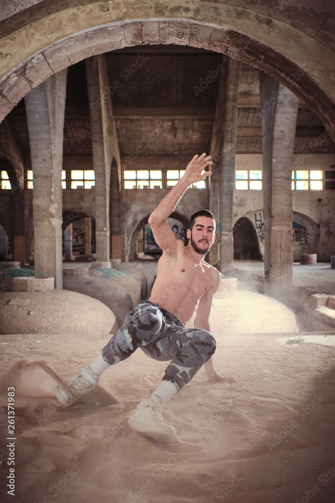 Man dancing breakdance on sand in building Man dancing breakdance on sand in building