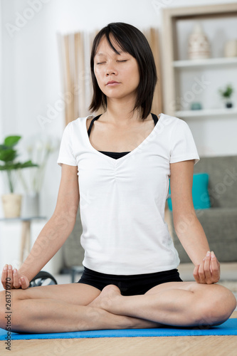 woman meditating at home in lotus position