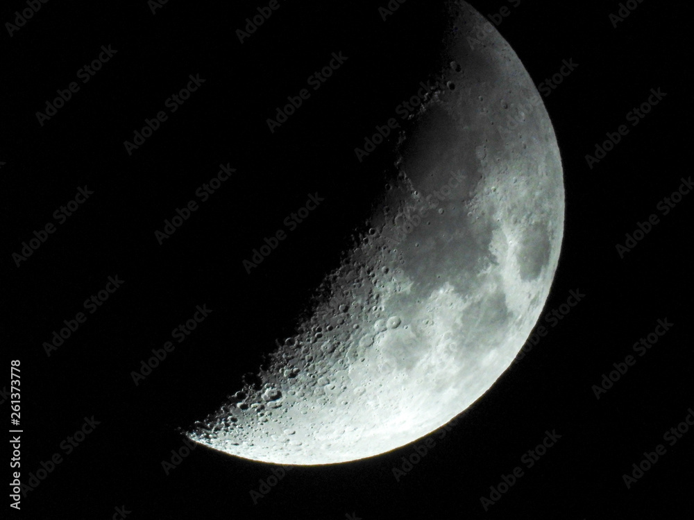 a crescent moon with clear visibility reveals many craters on the surface a crescent moon with clear visibility reveals many craters on the surface
