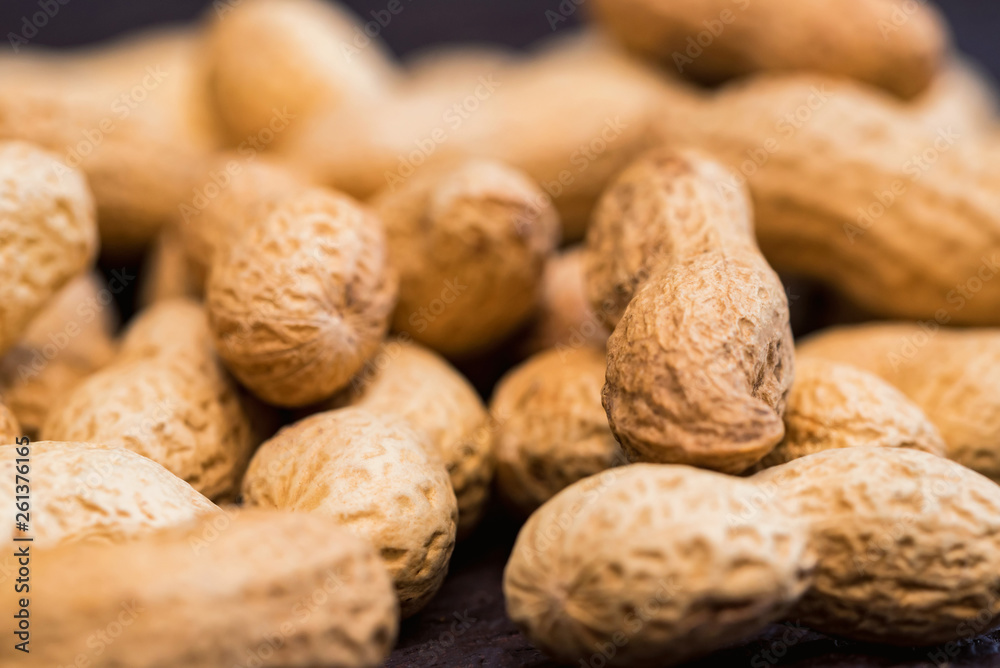 Close up pile of unpeeled peanuts on dark wooden background Close up pile of unpeeled peanuts on dark wooden background