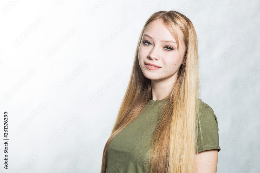 Portrait of a young beautiful smiling woman on a gray background. Portrait of a young beautiful smiling woman on a gray background.