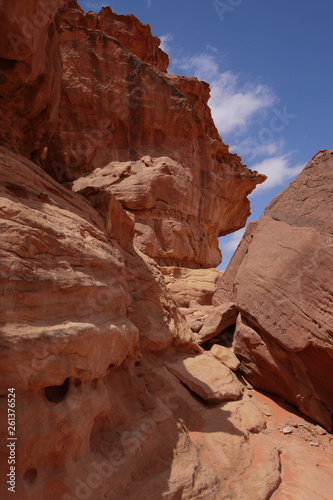 Felslandschaften im roten Wüstensand des Wadi Rum mit Verwehungen an Steinen