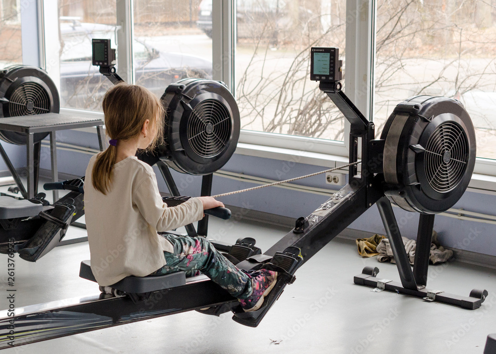 girl in the gym rowing club sitting on the rowing Ergometer and sports Stock Photo Adobe Stock