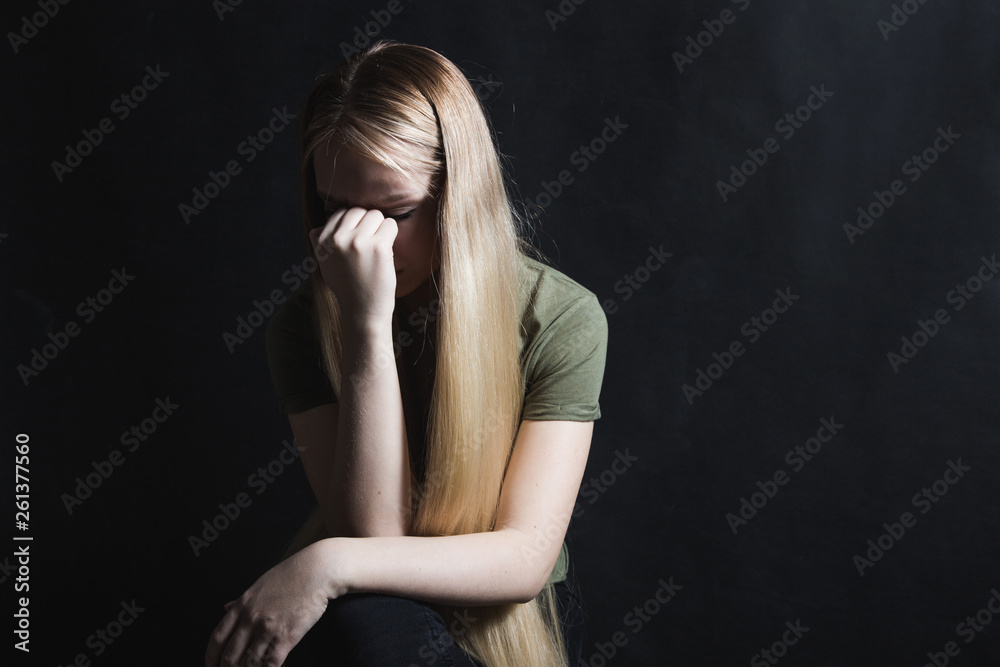 Sad young woman going to cry in a black background Sad young woman going to cry in a black background